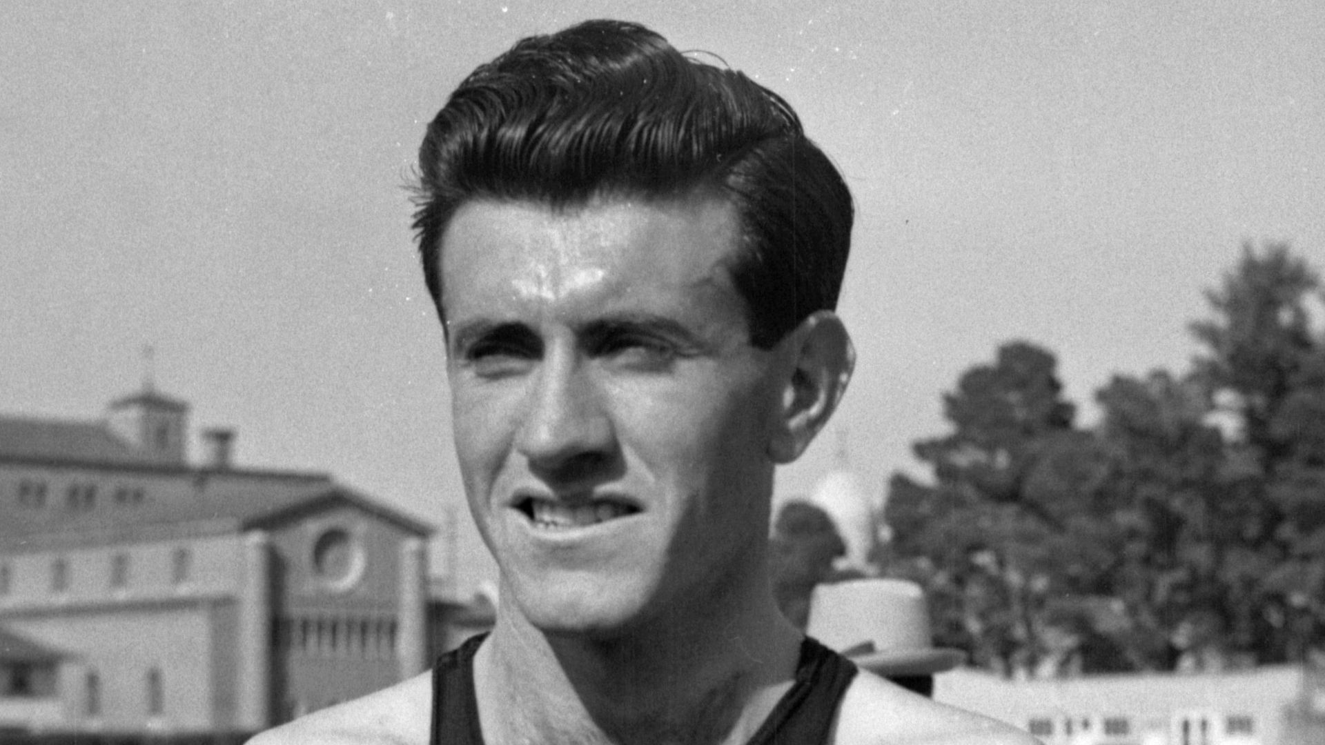 Louis Zamperini standing on Bovard Field, University of Southern California. He is wearing a Torrance High School track uniform.