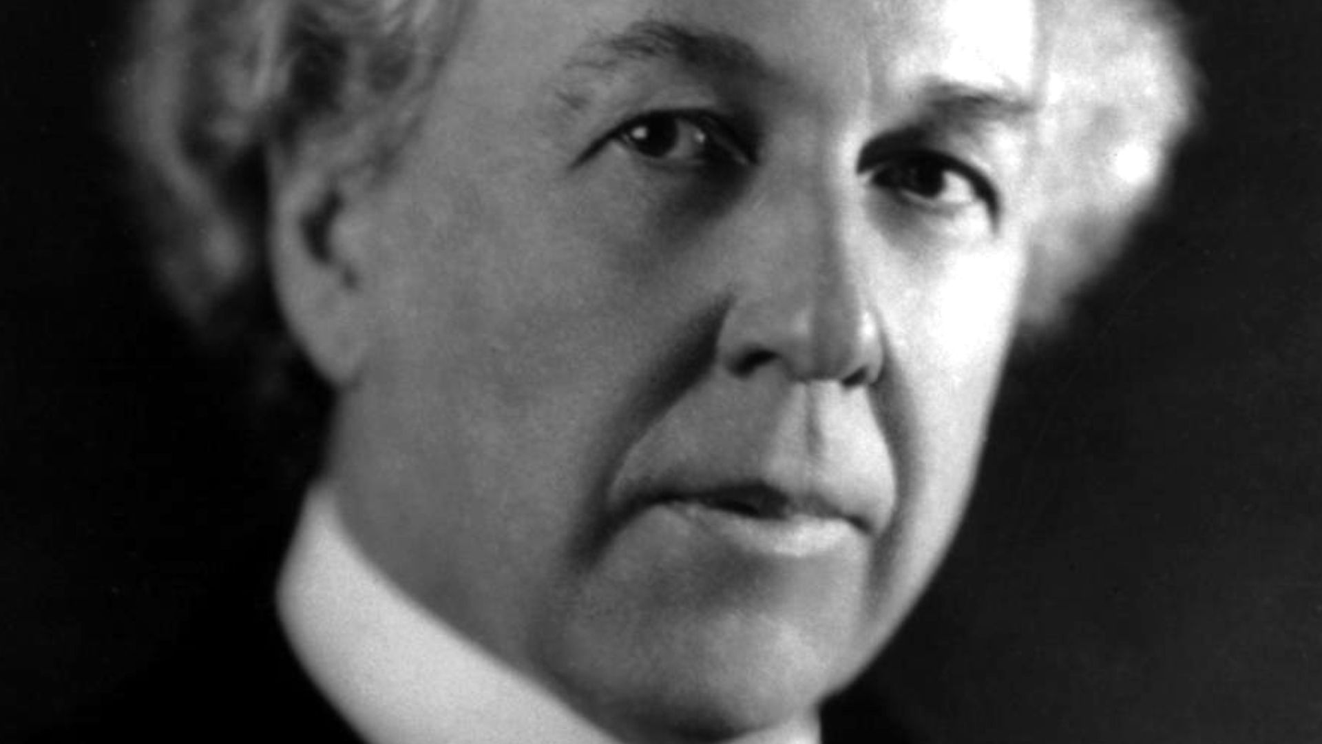 Frank Lloyd Wright, American architect, portrait, head and shoulders, facing right.