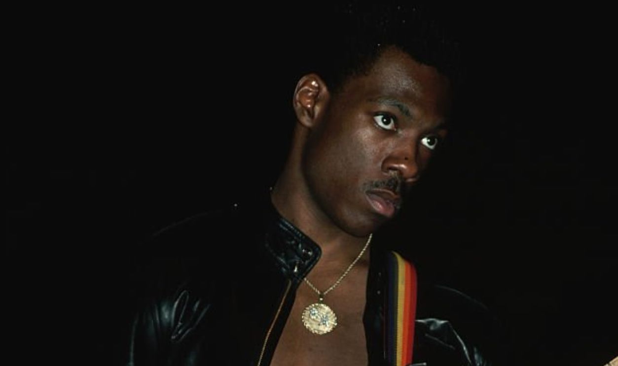 (Original Caption) : 1983-Comedian Eddie Murphy plays guitar during a live performance.