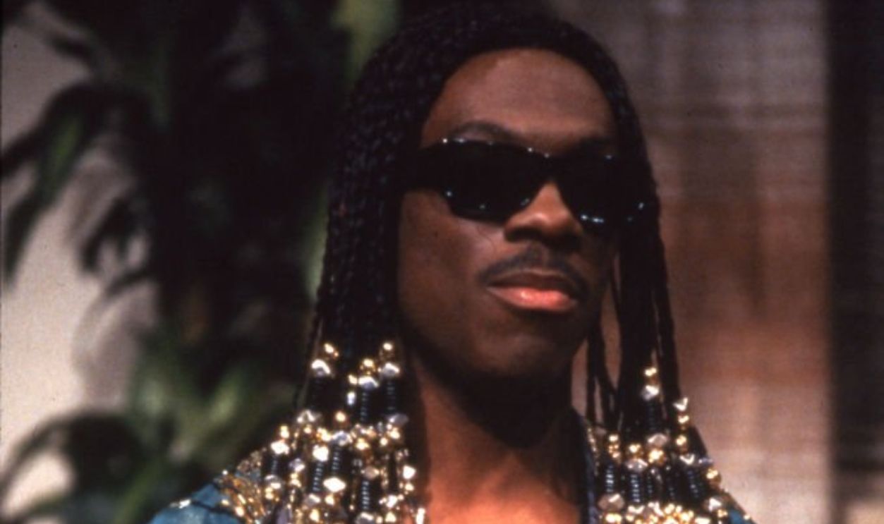 American comedian and actor Eddie Murphy performs as singer Stevie Wonder during a skit on the television show 'Saturday Night Live,' New York, New York, 1983.