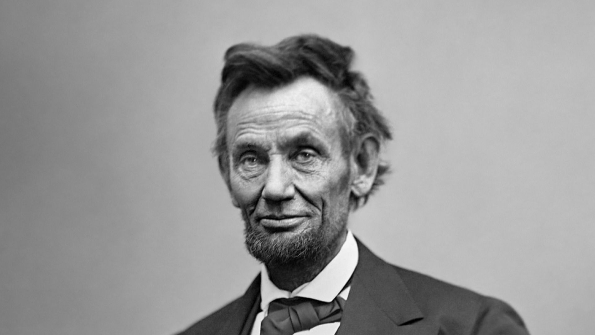 Abraham Lincoln, three-quarter length portrait, seated and holding his spectacles and a pencil