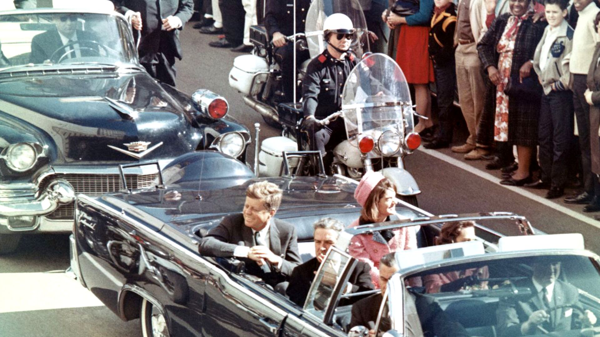 Picture of President Kennedy in the limousine in Dallas, Texas, on Main Street, minutes before the assassination.  Also in the presidential limousine are Jackie Kennedy, Texas Governor John Connally, and his wife, Nellie.