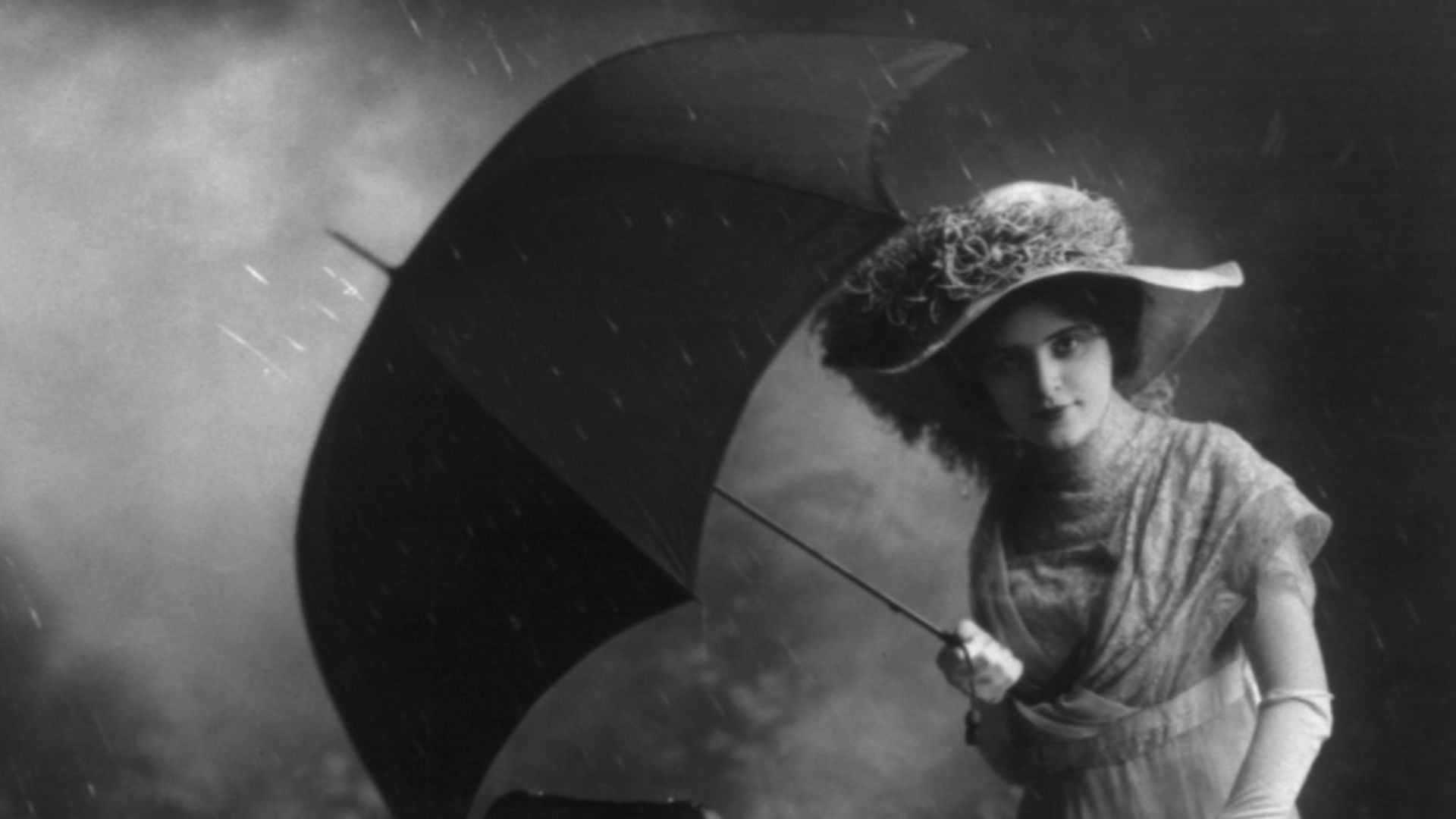 Title: Woman, holding umbrella, pushing baby in carriage equipped with rain cover (ad?)
Abstract/medium: 1 photographic print.
