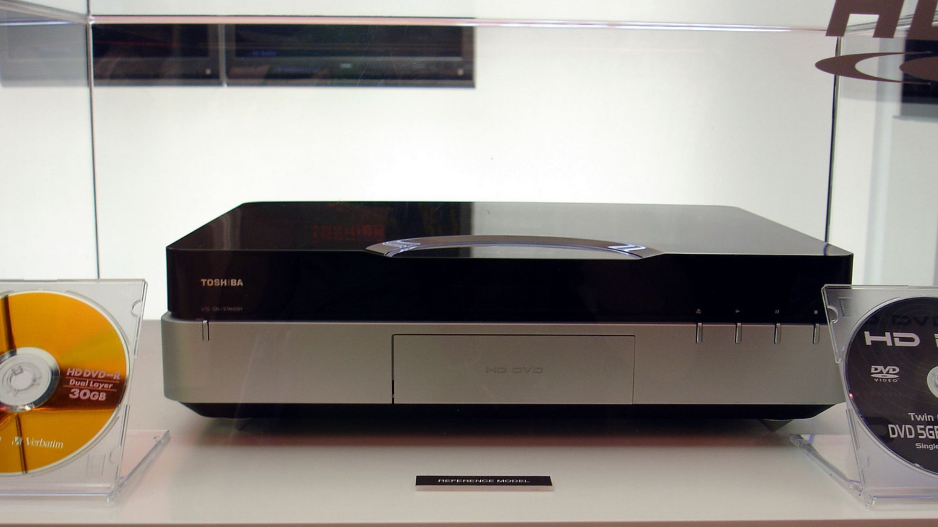 Deutsch: 
HD-DVD Player HBS-A-001 von Toshiba. Zusammen präsentiert mit einer Dual Layer HD-DVD mit 30GB Fassungsvermögen und einer Twin HD-DVD mit einem Layer als DVD mit 5GB und einem Layer HD-DVD mit 15GB Fassungsvermögen. Aufgenommen auf der IFA2005 i