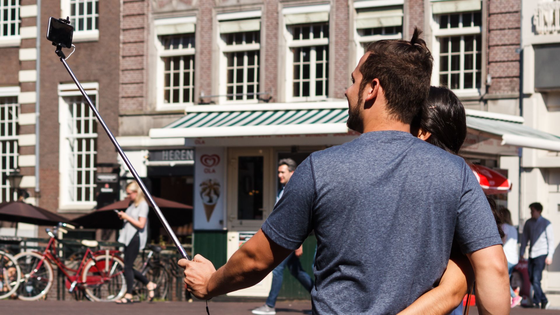 Couple taking a self-portrait using a selfie stick at Konigssluis, Amsterdam, the Netherlands