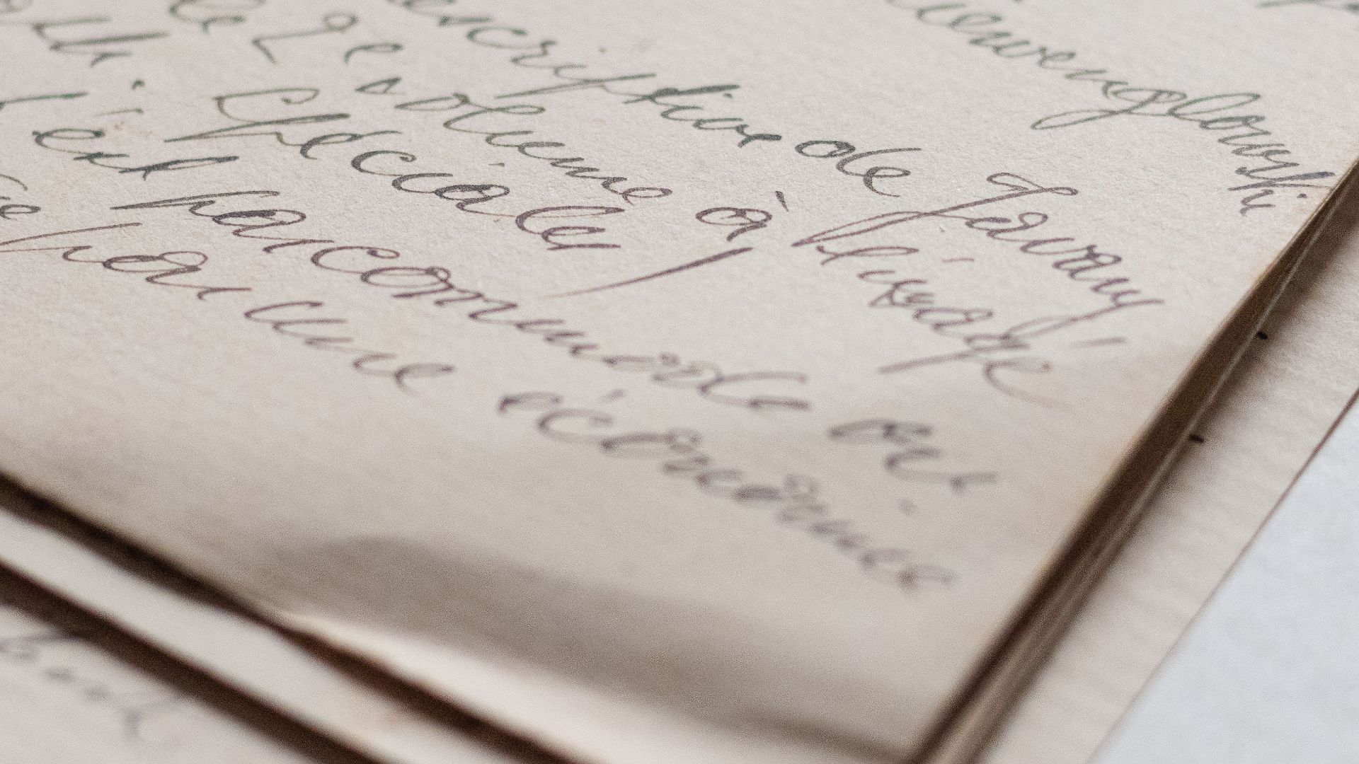 Close-up of a vintage handwritten letter with elegant script on textured paper.