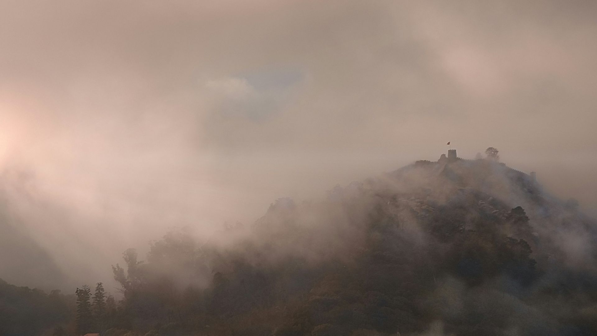 Misty mountain peak with clouds and sunlight