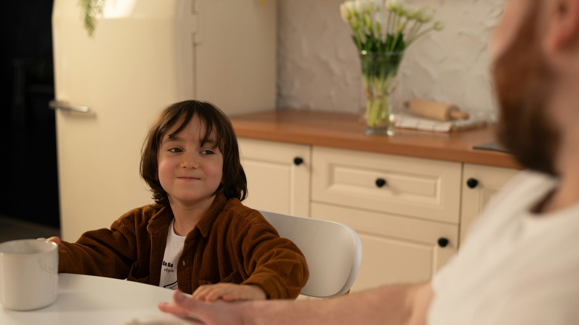 a little girl sitting at a table with a man