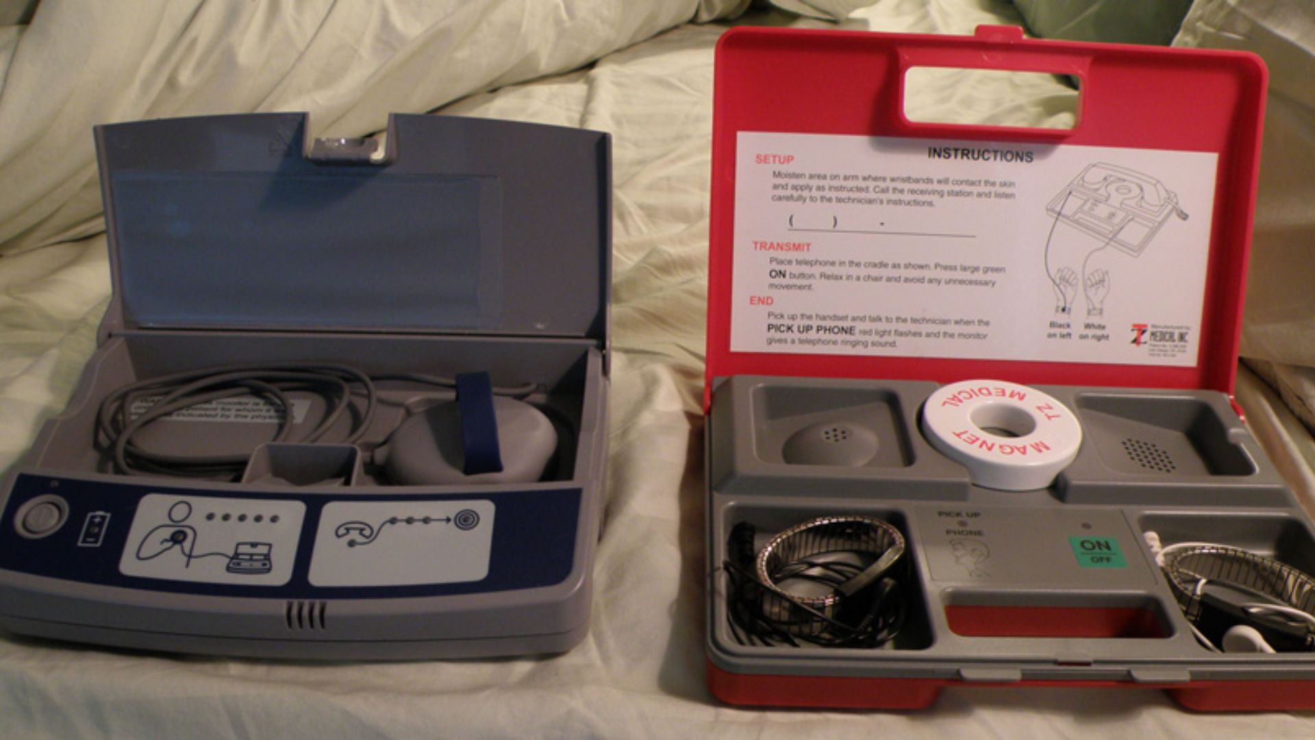 This image shows two different kinds of devices used for the remote monitoring of pacemaker patients.  The one on the left, the gray device, is the more advanced device that actually communicates with the pacemaker through the peripherial that is placed o