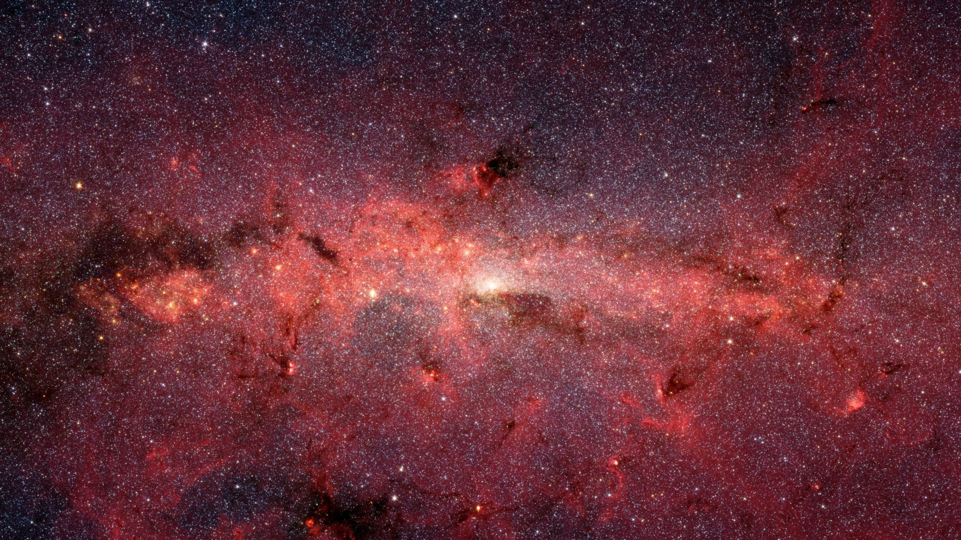 The center of our Milky Way galaxy is hidden from the prying eyes of optical telescopes by clouds of obscuring dust and gas. But in this stunning vista, the Spitzer Space Telescope's infrared cameras penetrate much of the dust, revealing the stars of the 
