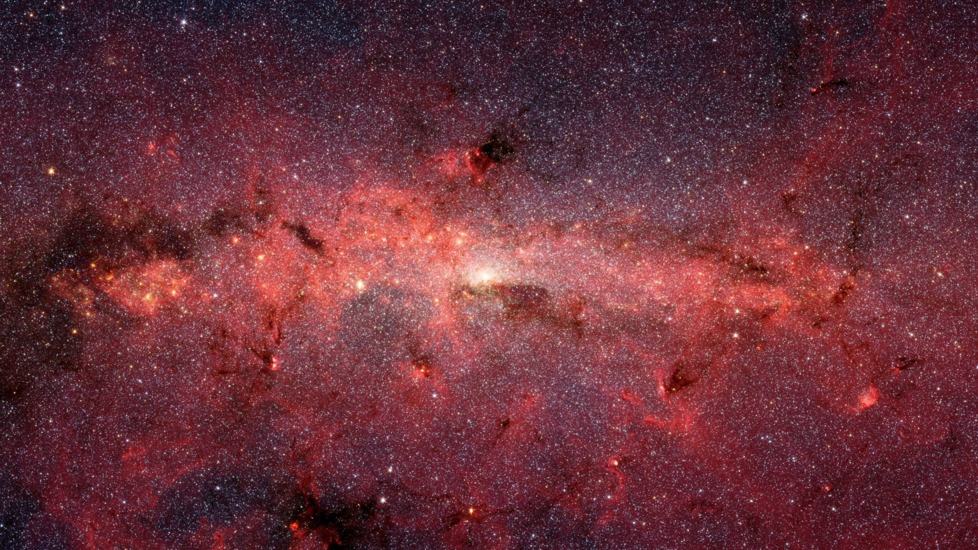 The center of our Milky Way galaxy is hidden from the prying eyes of optical telescopes by clouds of obscuring dust and gas. But in this stunning vista, the Spitzer Space Telescope's infrared cameras penetrate much of the dust, revealing the stars of the 