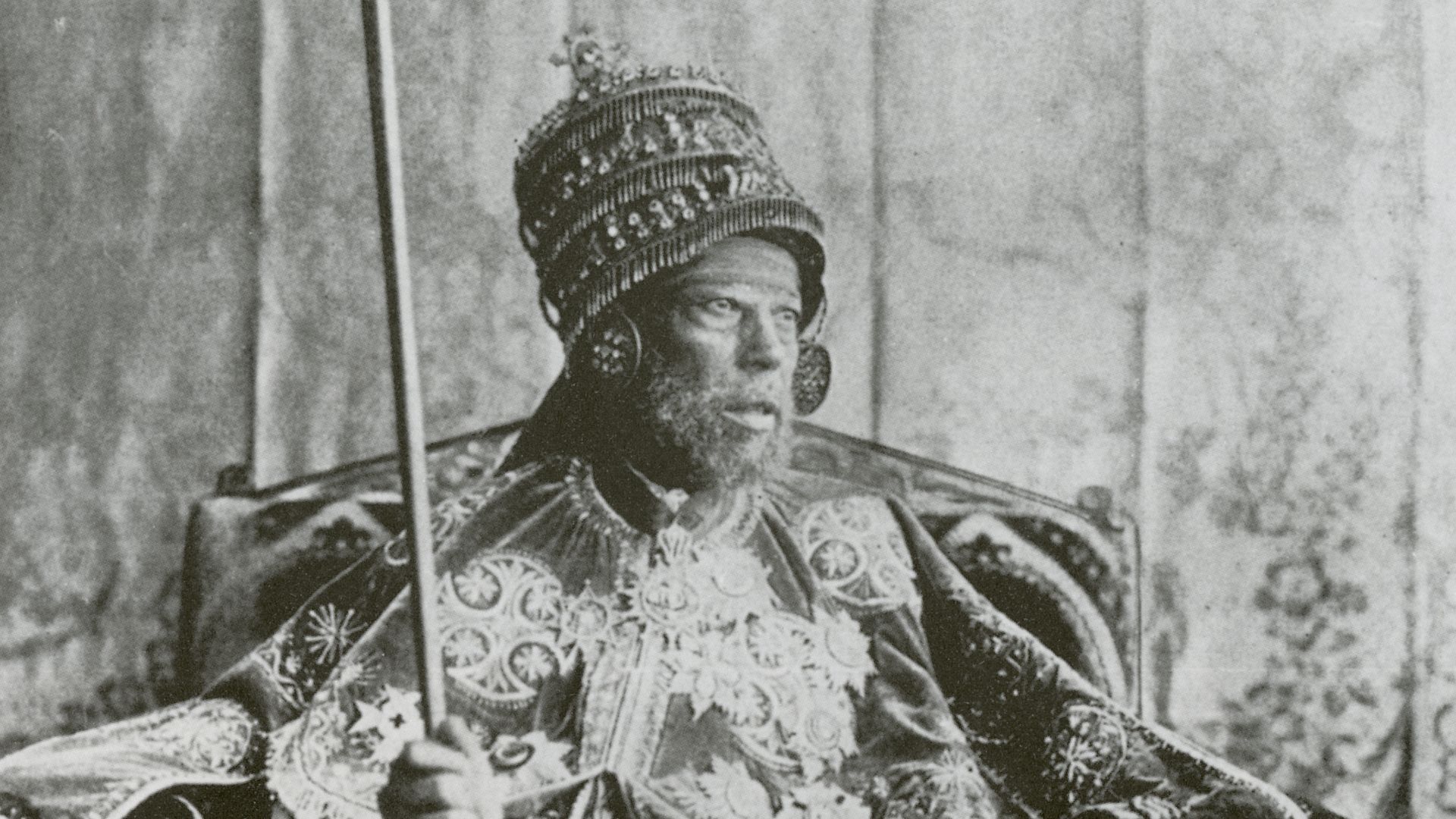 Emperor Menelik II photographed on the throne in coronation garb.