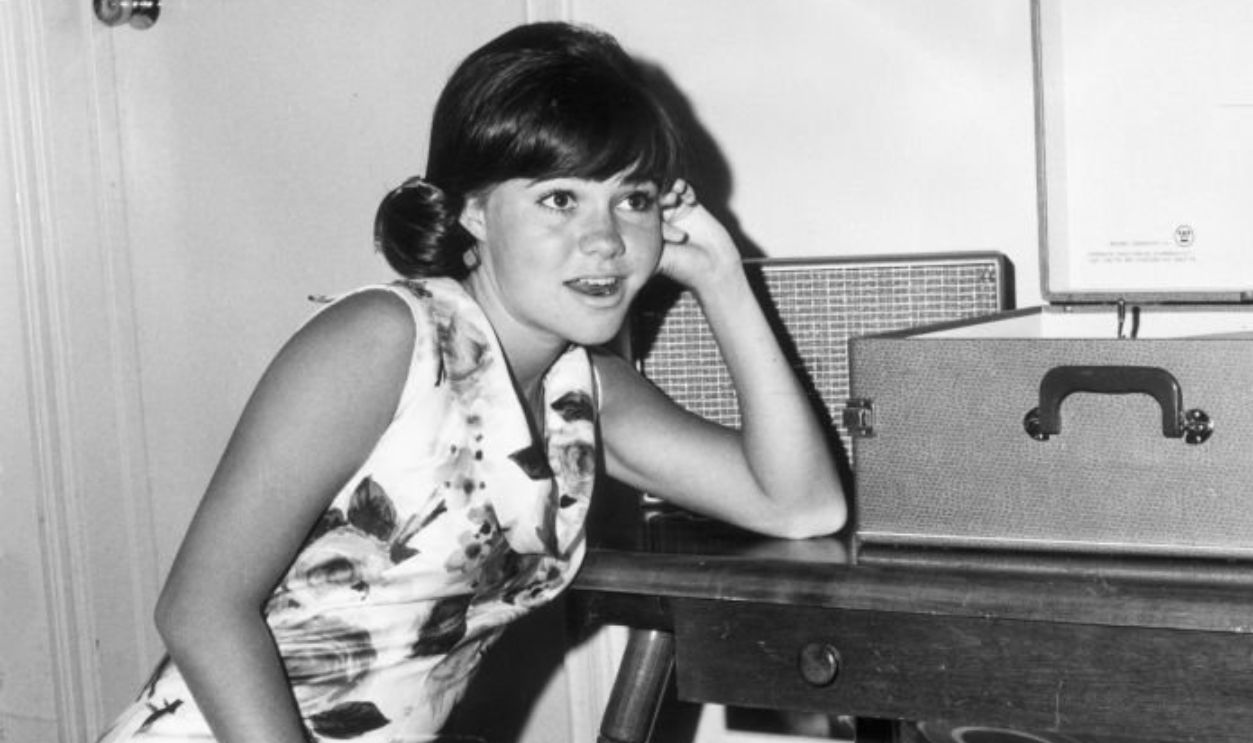 circa 1965: American actor Sally Field sitting on the floor listening to records.