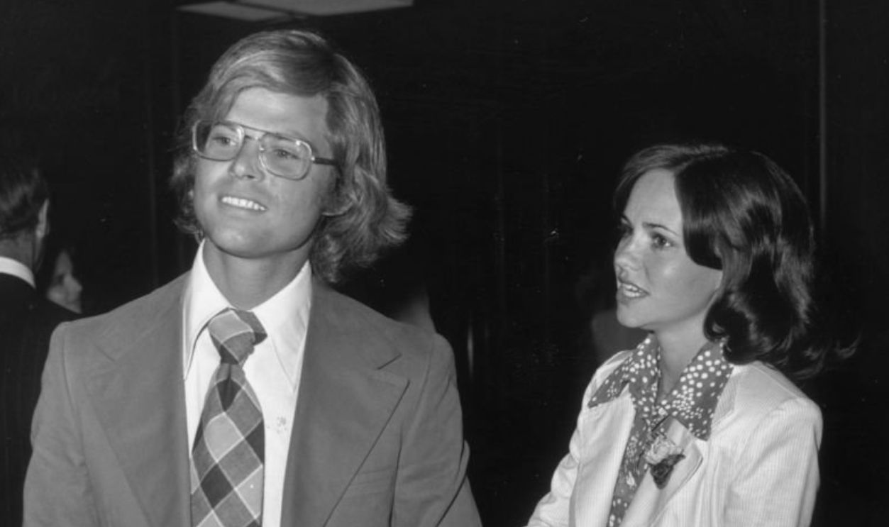circa 1972: American actor Sally Field with her first husband, Steve Craig, at party. Craig wears a suit with a plaid tie; Field wears a pants suit with a flower in the lapel. 