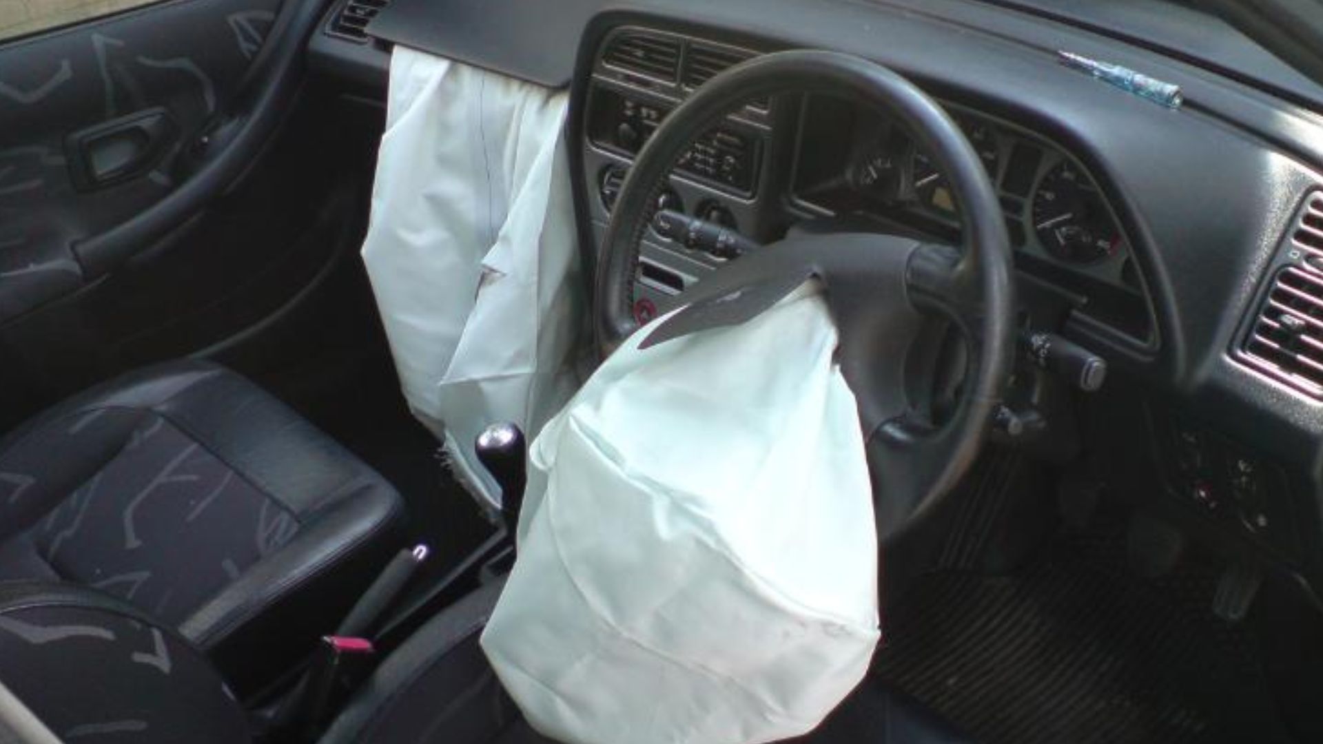 Interior photo of a Peugeot 306 with airbags deployed.