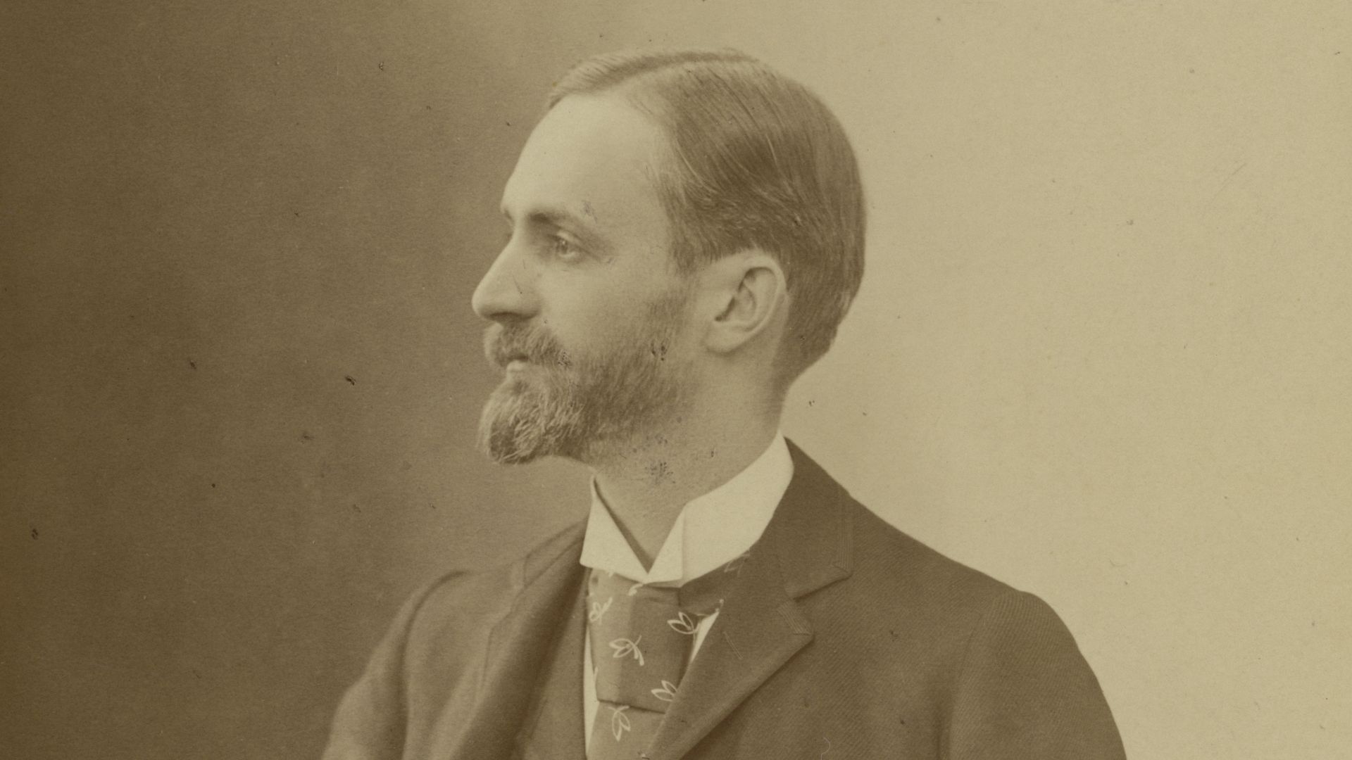 Portrait of George Eastman (1854-1932) , founder of Eastman Kodak Company. Eastman is standing, looking to his right. His left hand rests on a table with books on top of it. By founding the Eastman Kodak Company in 1888, George Eastman popularized the use