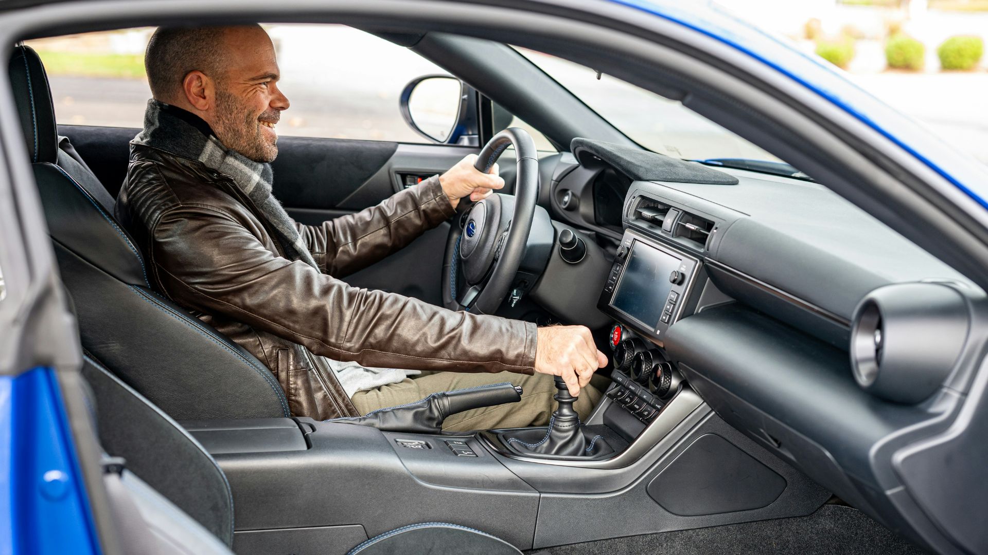 A man sitting in a car with a steering wheel