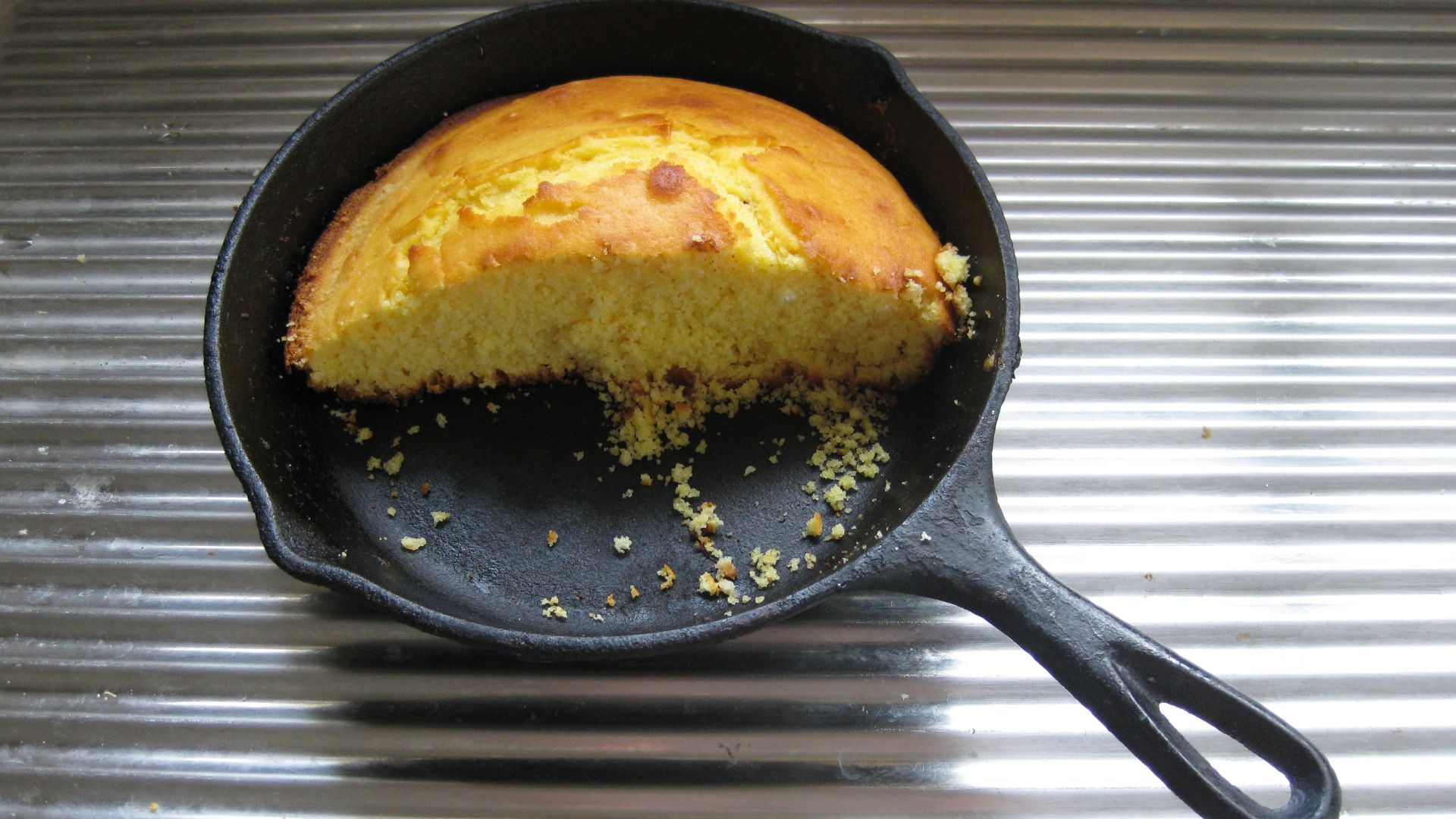 Half a loaf of cornbread in cast iron fry pan.