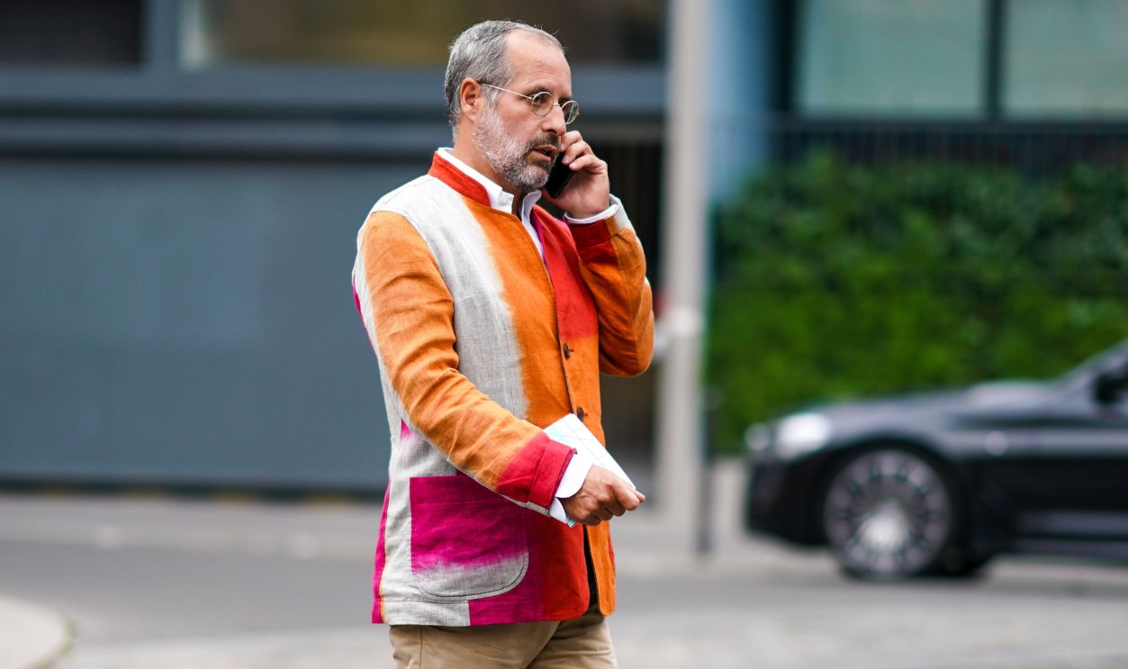 A guest wears gradient orange and hot pink Nehru collar jacket, beige pants, orange Nike sneakers , outside Hermes, during Paris Fashion Week - Menswear Spring/Summer 2020, on June 22, 2019 in Paris, France