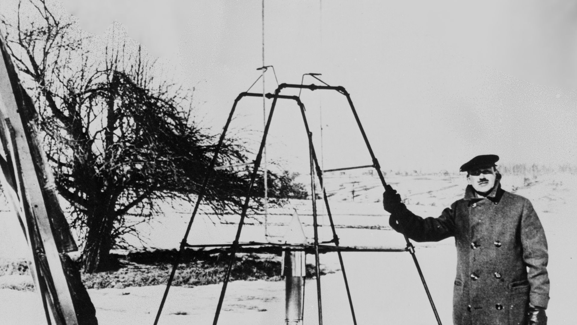 Dr. Robert H. Goddard and liquid oxygen-gasoline rocket in the frame from which it was fired on March 16, 1926, at Auburn, Mass. It flew for only 2.5 seconds, climbed 41 feet, and landed 184 feet away in a cabbage patch. From 1930 to 1941, Dr. Goddard mad