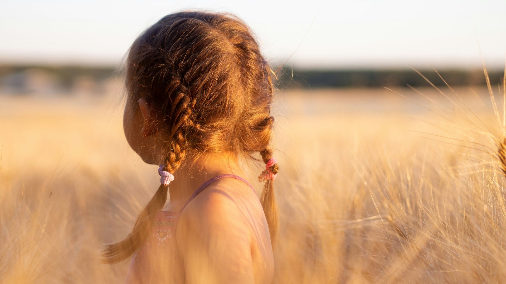 girl wearing pink camisole on brown plant during daytime