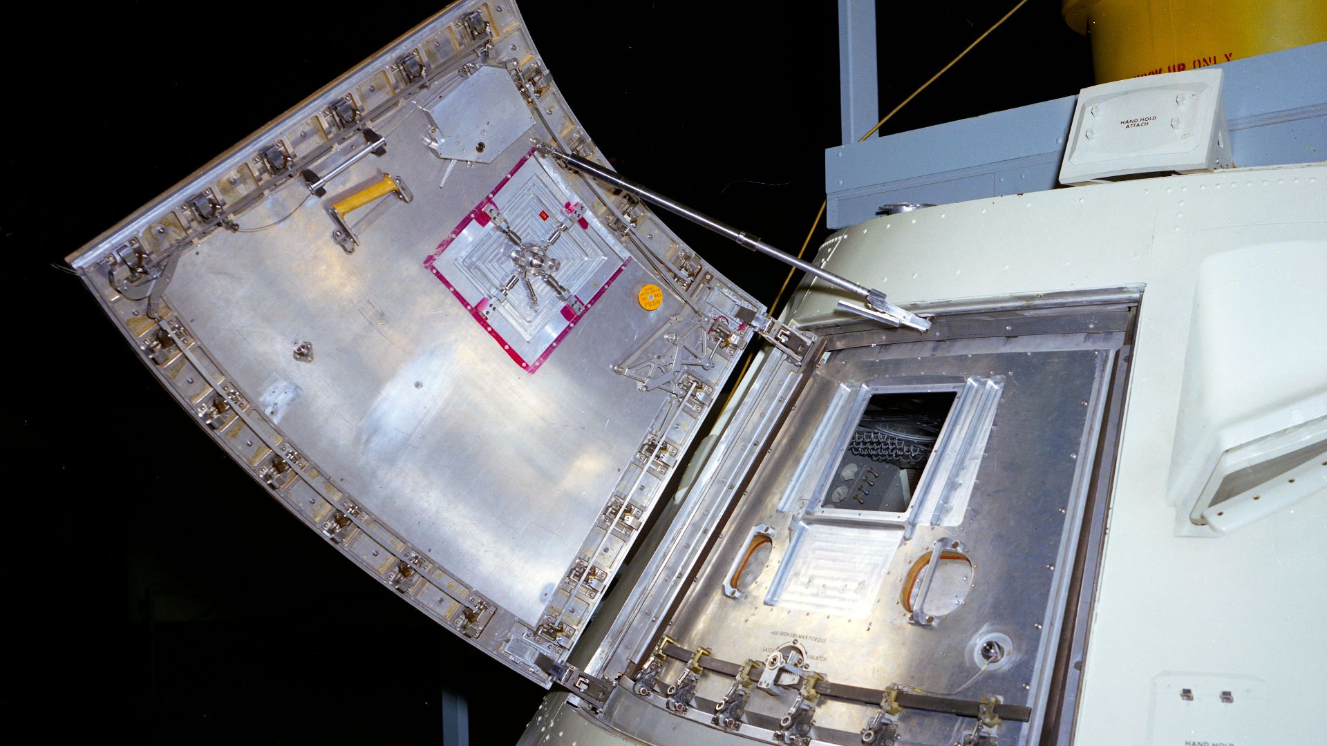 Picture of an Apollo block I Command Module with open outer hatch. Image ID: s66-57577. Picture appears on page 226 of the NASA official history Chariots for Apollo, NASA SP-4205 https://history.nasa.gov/SP-4205.pdf