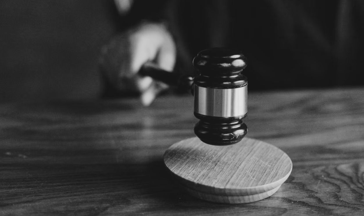 A gavel striking a sound block, symbolizing justice and legal authority in a courtroom setting