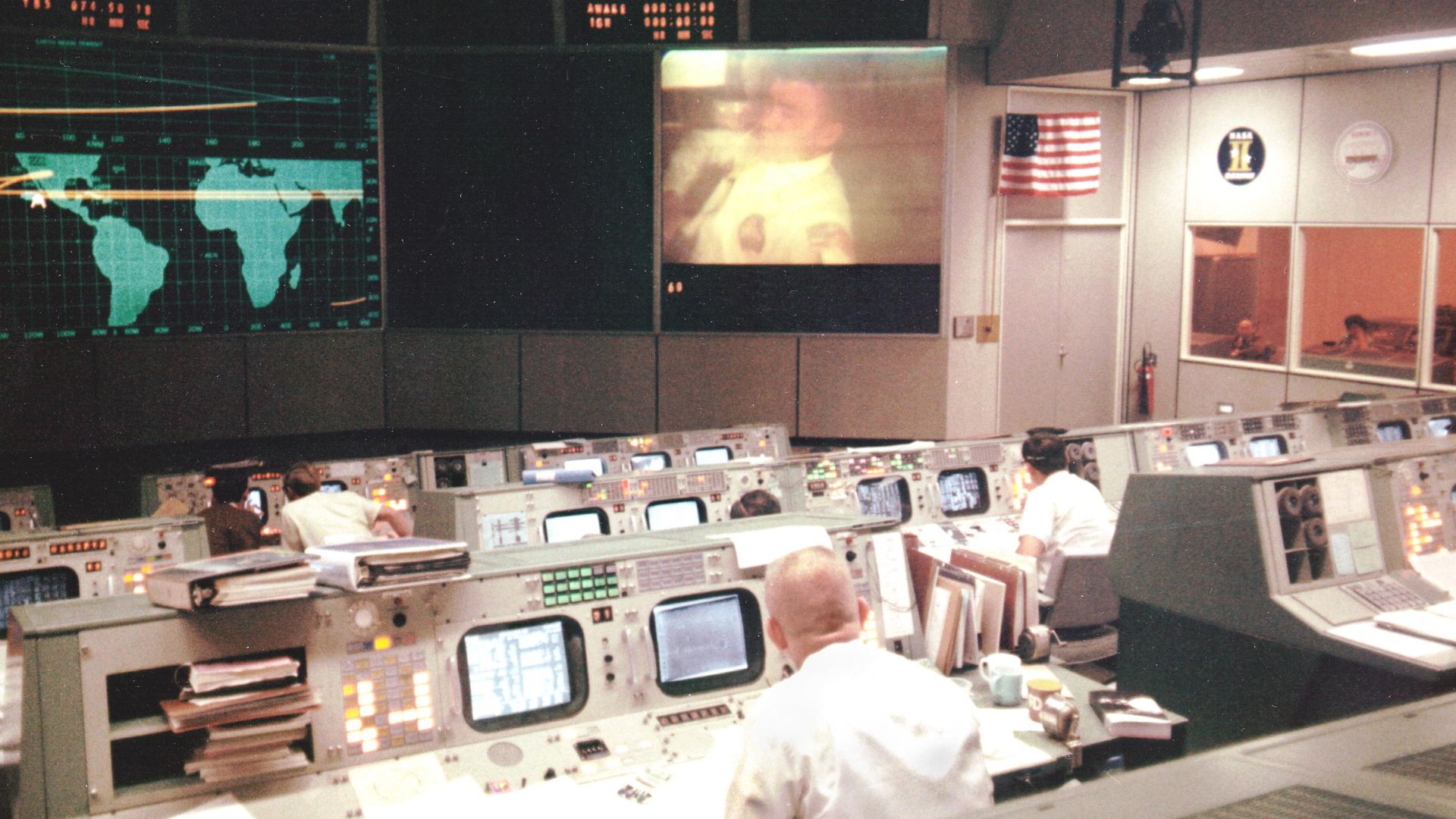 Overall view of the Mission Operations Control Room in the Mission Control Center at the Manned Spacecraft Center, during the fourth television transmission from the Apollo 13 spacecraft while enroute to the Moon. 
Eugene F. Kranz (foreground, back to cam