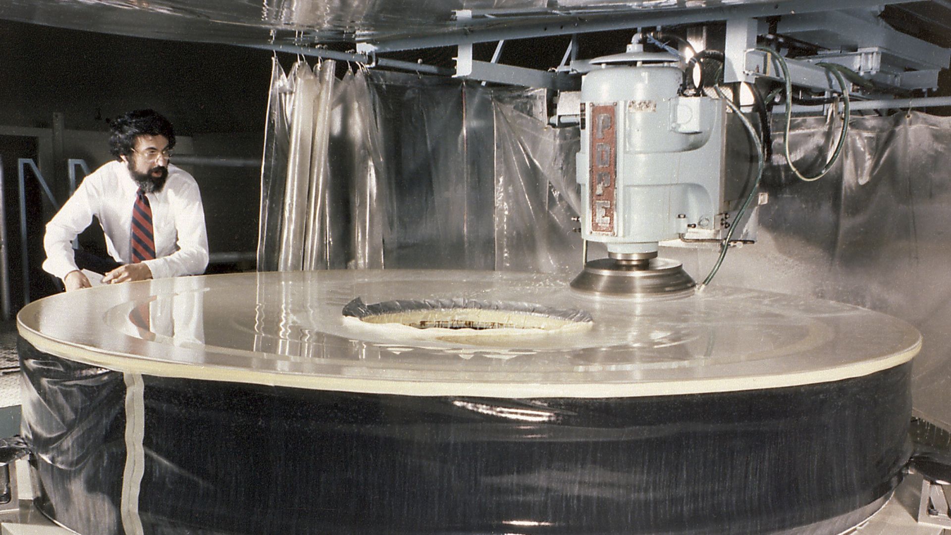 Hubble Space Telescope Primary Mirror: This photograph shows the Hubble Space Telescope's (HST's) Primary Mirror being ground at the Perkin-Elmer Corporation's large optics fabrication facility. After the 8-foot diameter mirror was ground to shape and pol