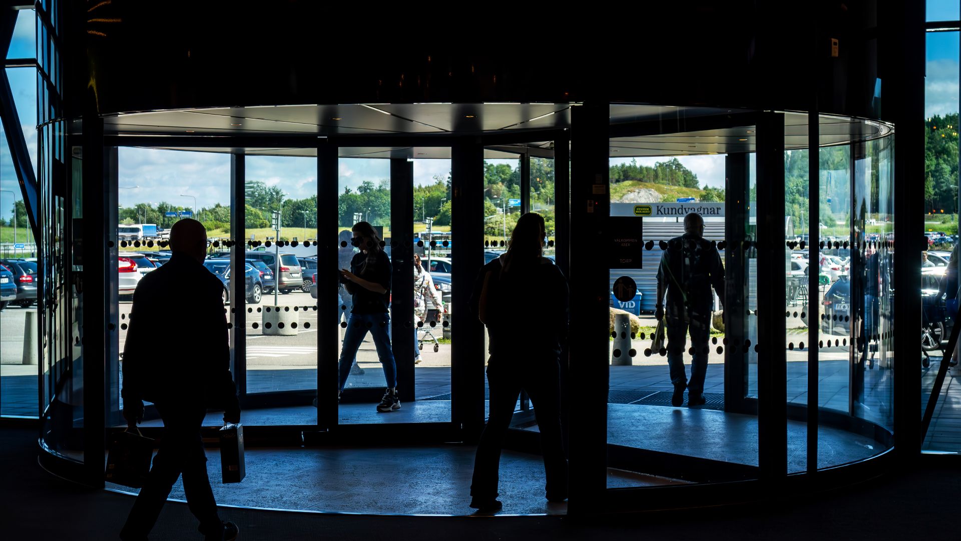 People using the revolving doors of the entrance to Torp shopping mall, Uddevalla Municipality, Sweden.