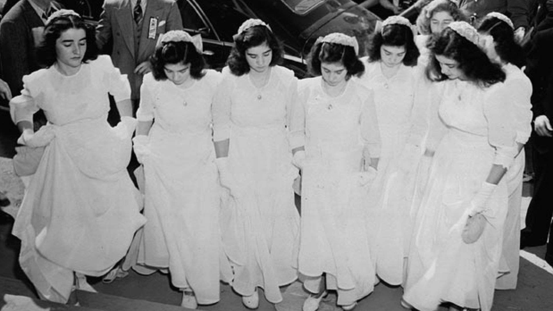The Dionne quintuplets and their sisters arrive at Lansdowne Park to take part in a program of religious music during the Marian Congress at which 250,000 Catholics prayed for peace and celebrated the centenary of the Ottawa archdiocese.