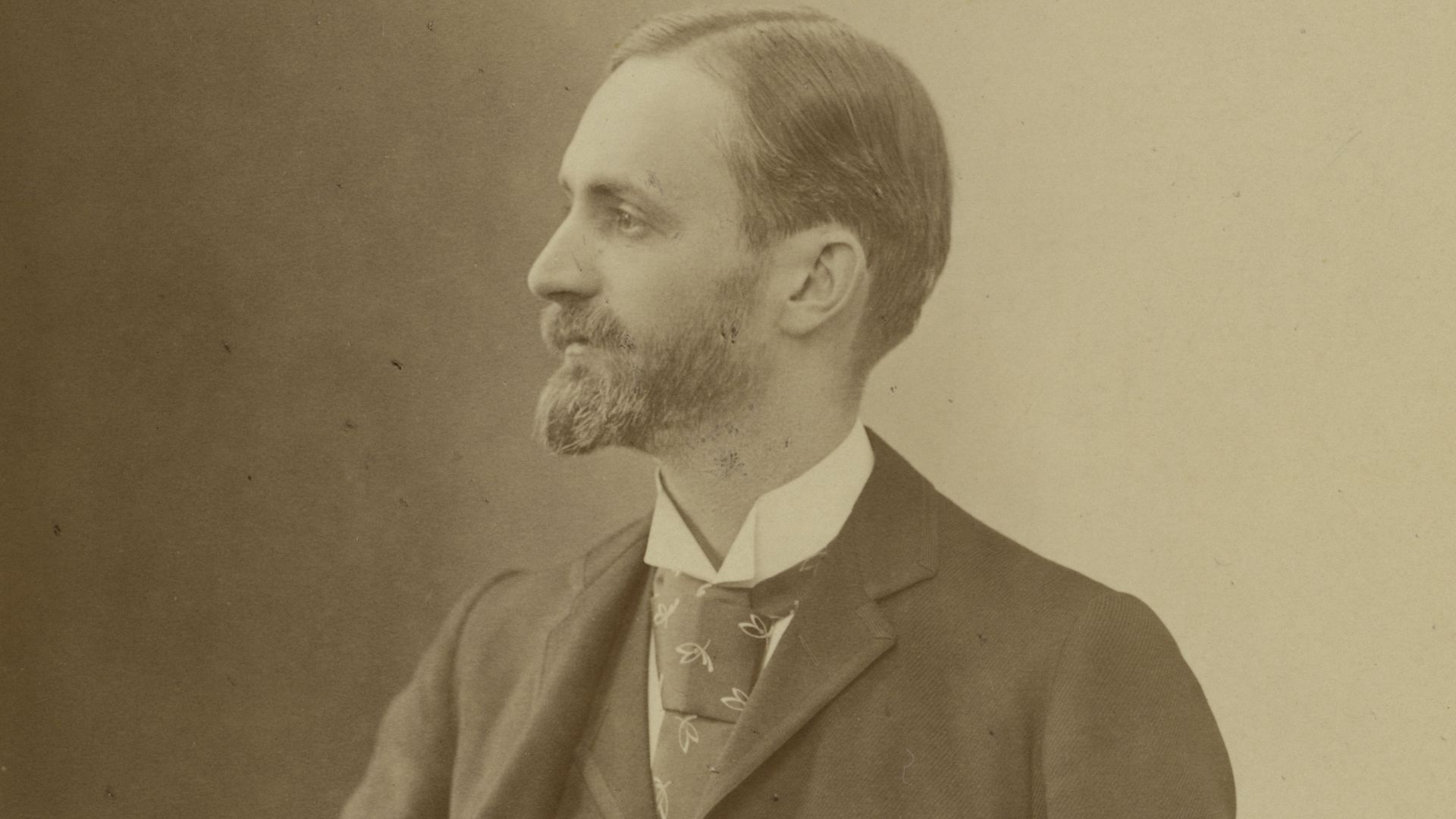 Portrait of George Eastman (1854-1932) , founder of Eastman Kodak Company. Eastman is standing, looking to his right. His left hand rests on a table with books on top of it. By founding the Eastman Kodak Company in 1888, George Eastman popularized the use