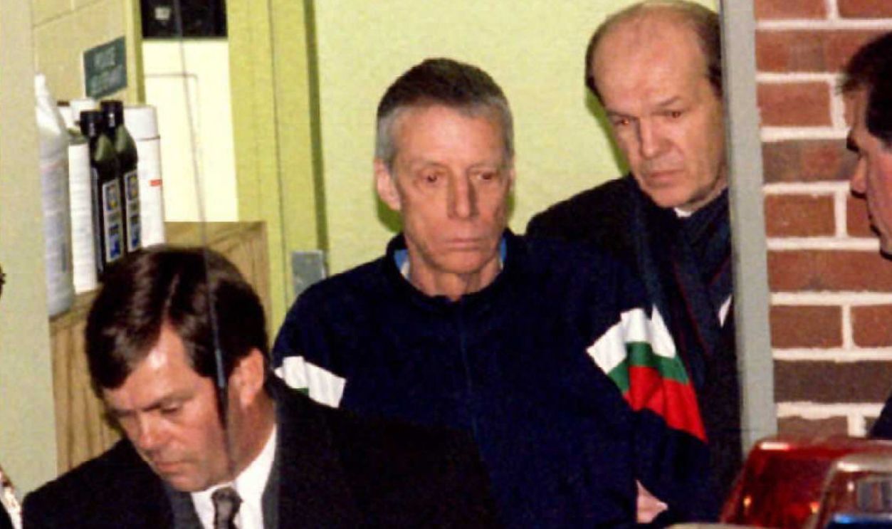 Getty Images - 52027861 - Murder suspect John du Pont (C) is taken from the Newtown Township Police Station in Pennsylvania to a waiting police car following his processing, 28 January, on charges that he shot and killed Olympic gold medal wrestler David Schultz on Friday 26 January. Dupont was captured on his 800 acre estate following a 48-hour standoff with police.