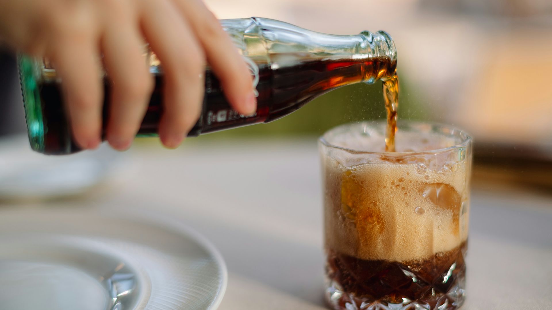 a person pouring a beverage into a glass