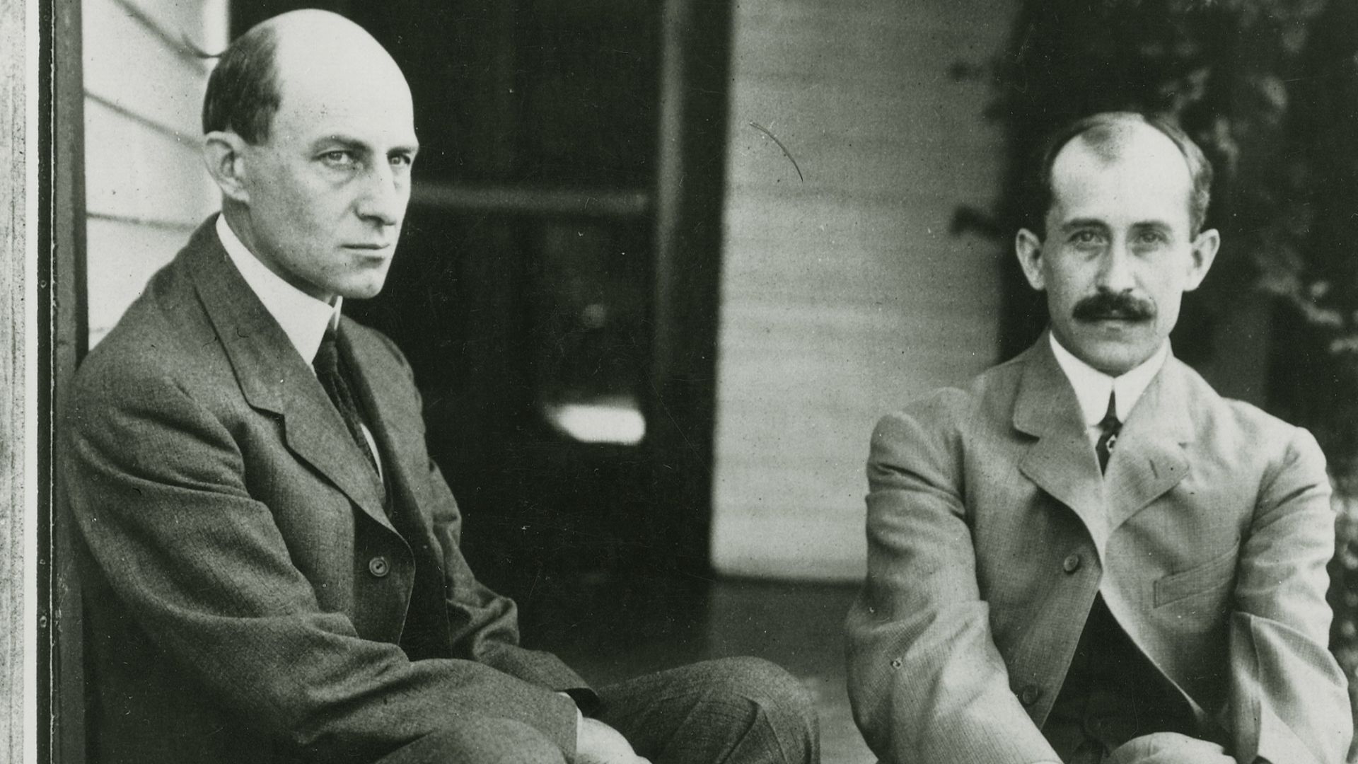 Wilbur, left, and Orville Wright sit on the porch steps of their Dayton, Ohio, home in June 1909.