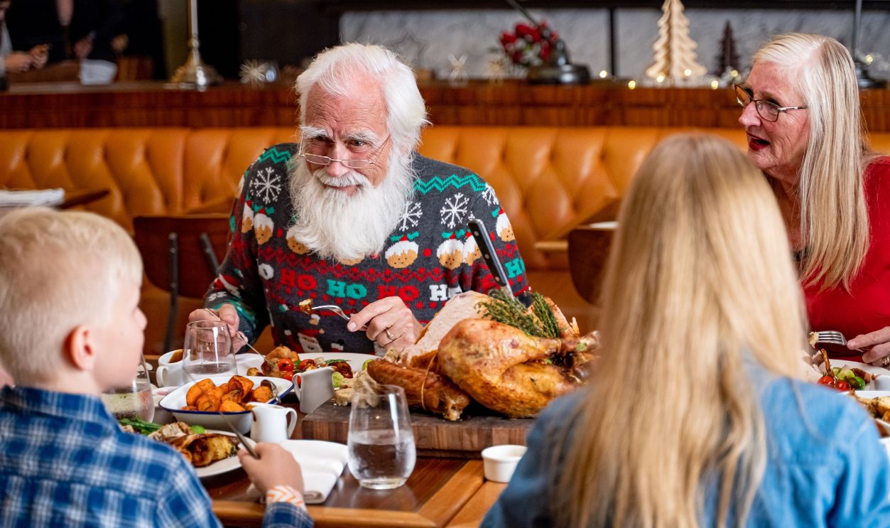 Family enjoying a festive meal in a Dubai restaurant, featuring joyful expressions and holiday decor