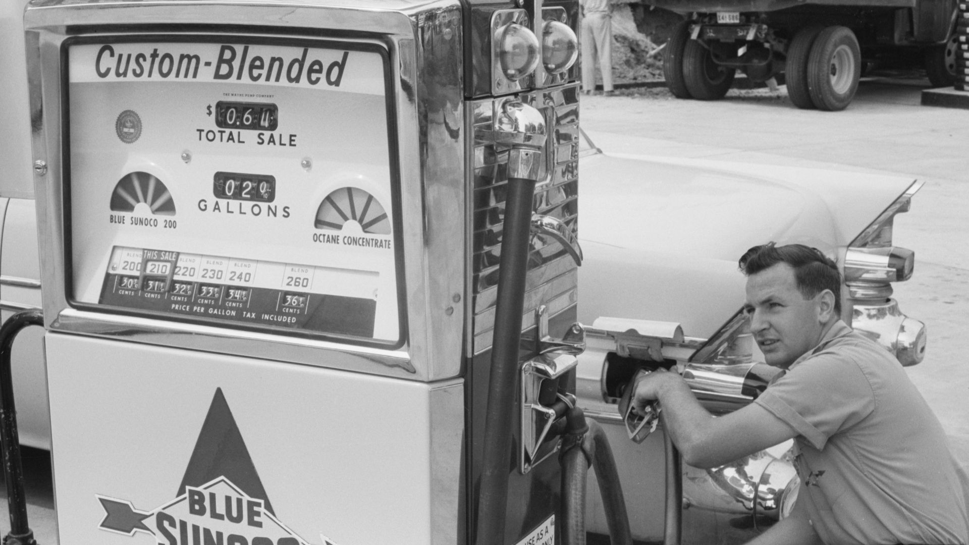 Gas station attendant filling a car tank with custom blend gas, at a Sunoco gas station, Washington, D.C. area