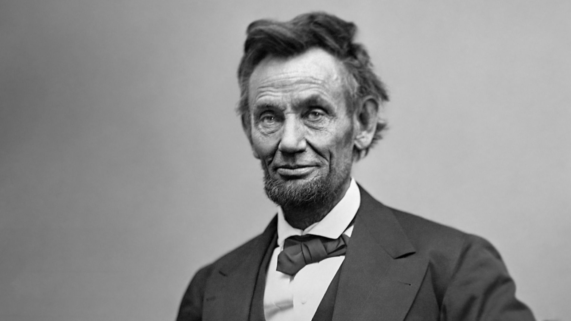 Abraham Lincoln, three-quarter length portrait, seated and holding his spectacles and a pencil