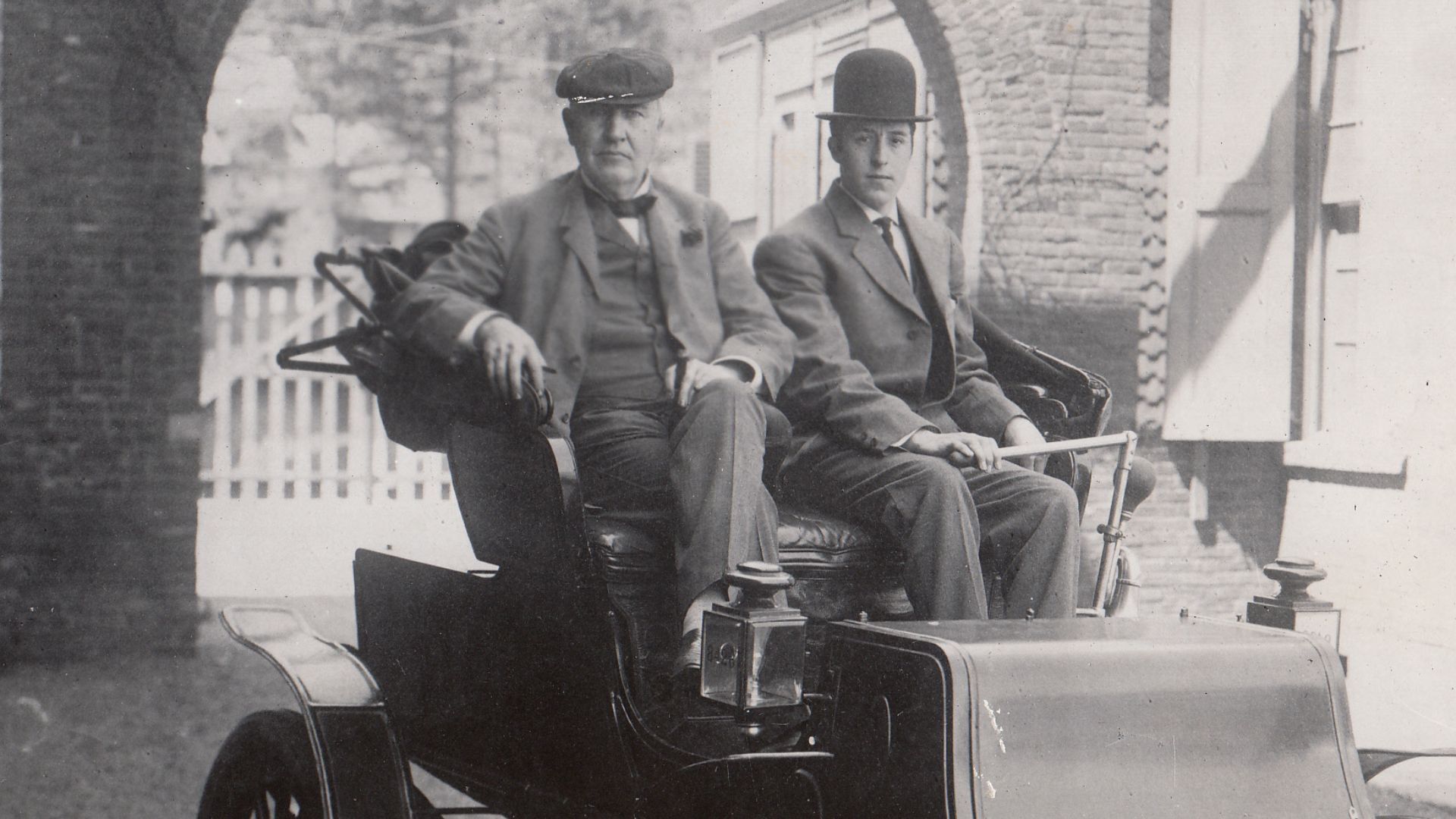 Thomas Edison and George Meister in a Studebaker electric runabout.
Keywords: thomas edison; west orange; laboratory complex; building 5; building 5 exterior; building 1; building 1 exterior; gatehouse; main street; automobiles; umbrella signature; Edison