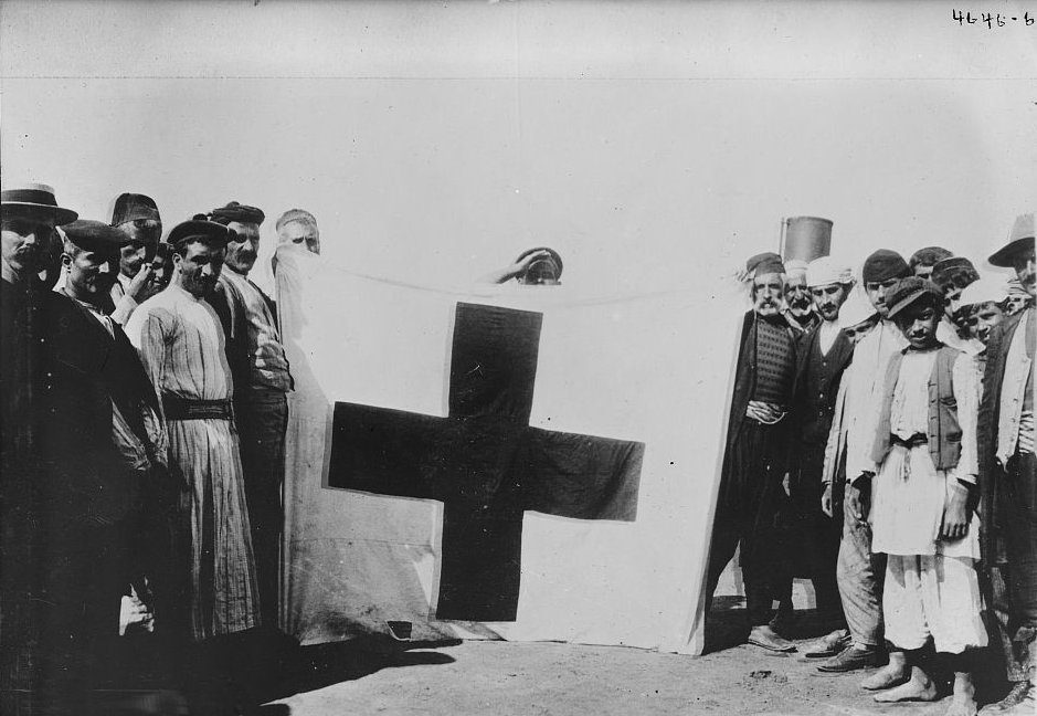 Red Cross flag held by people