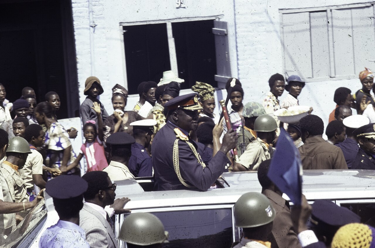 President Idi Amin (Uganda) standing in an open car - 1976
