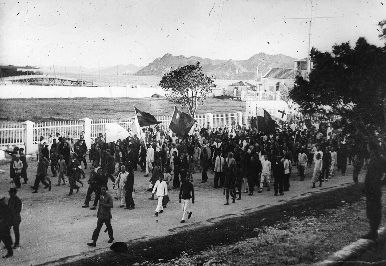 September 1911 On the first day of the outbreak of the Revolution in China 1911, a crowd are marching along the sea front with banners.