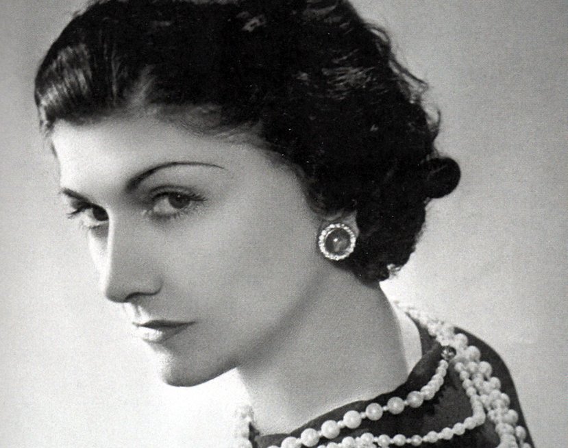 Coco Chanel wearing black top and white pearls