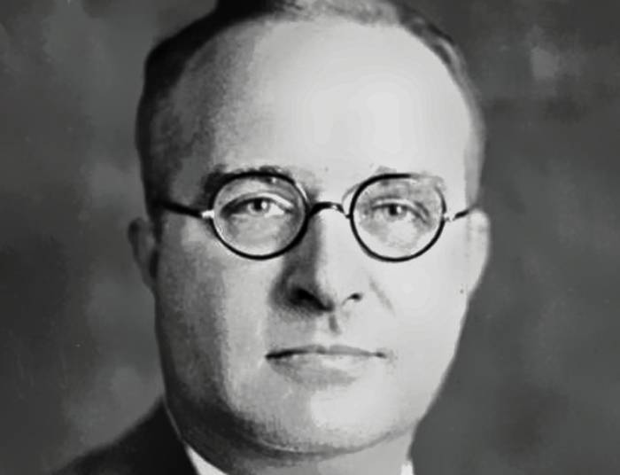 Thomas Midgley Jr in suit and glasses