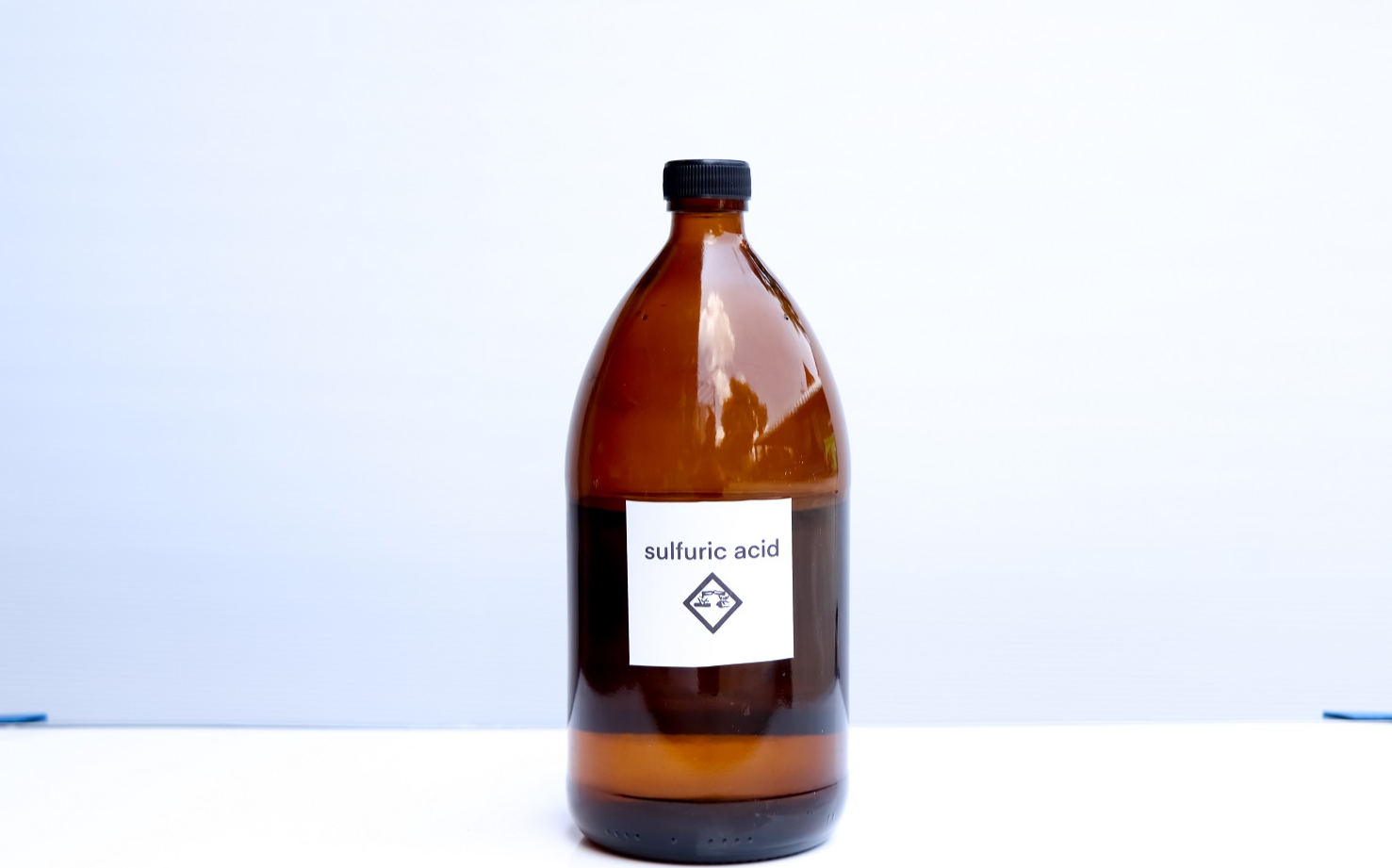 Sulfuric acid in bottle on table.