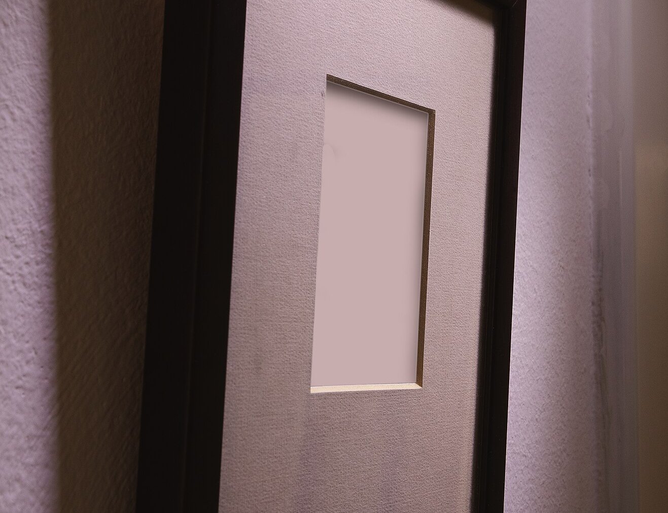 Empty wooden picture frame hanged on the wall, viewed from aside