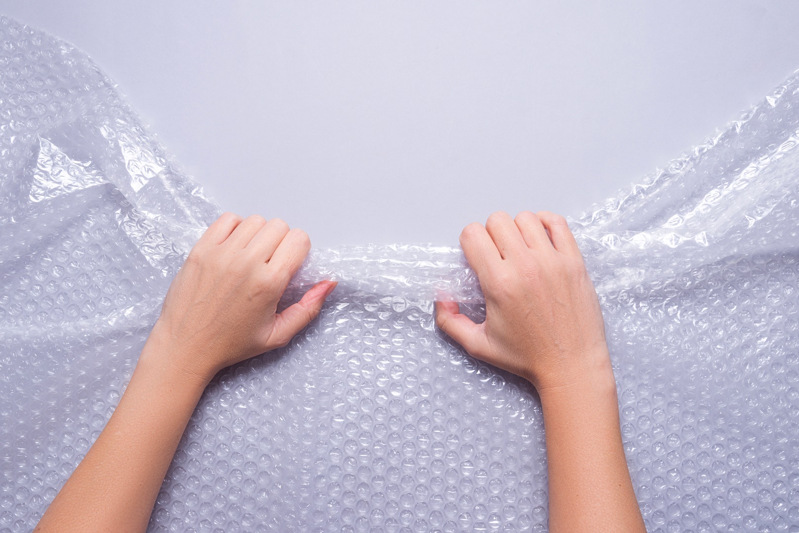 The hands pull the bubble wrap