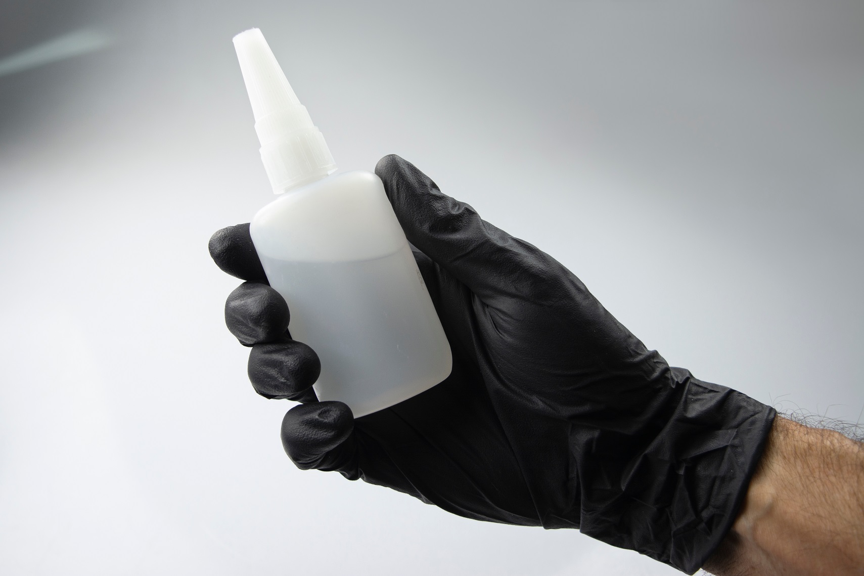 hand with glove and cyanoacrylate adhesive glue