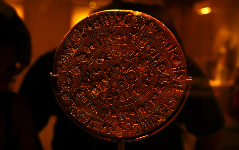 Side 1 of the Phaistos Disc on a blurred background