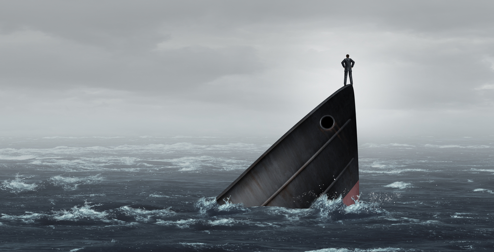 Sinking ship metaphor and failing business despair concept